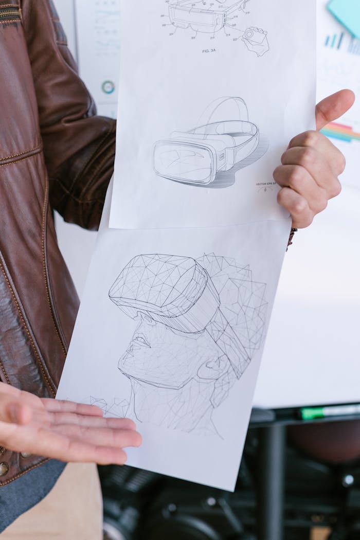 Close-up of VR headset design sketches held by a person showcasing innovative technology ideas.